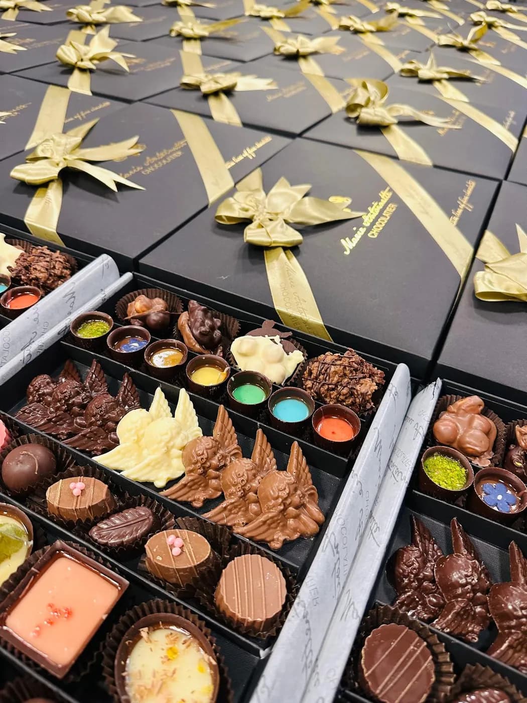 Açık kutuda truffle, praline, Cup ve melek figürlü çikolatalardan oluşan seçki
